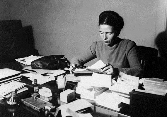 SIMONE DE BEAUVOIR LISANT A SON BUREAU EN 1953